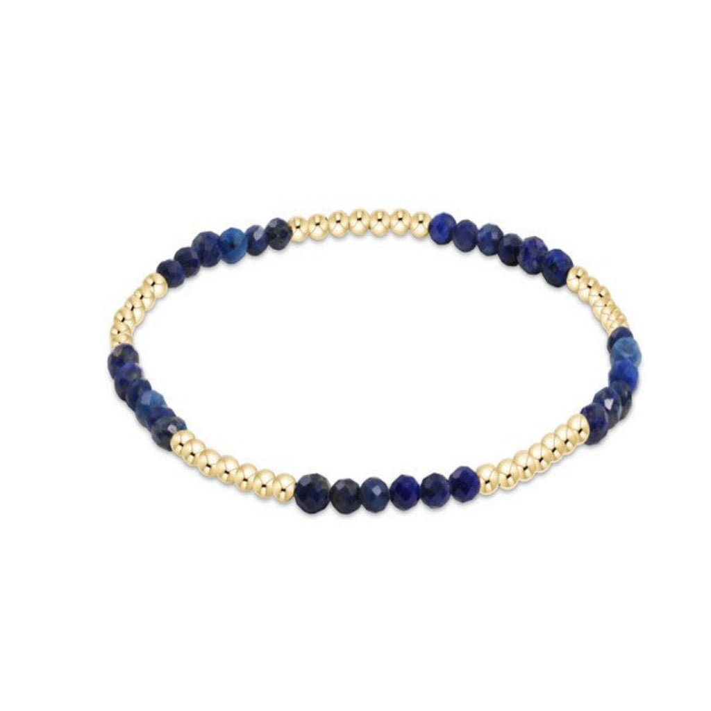 Bracelet with blue beads and gold accents on a white background