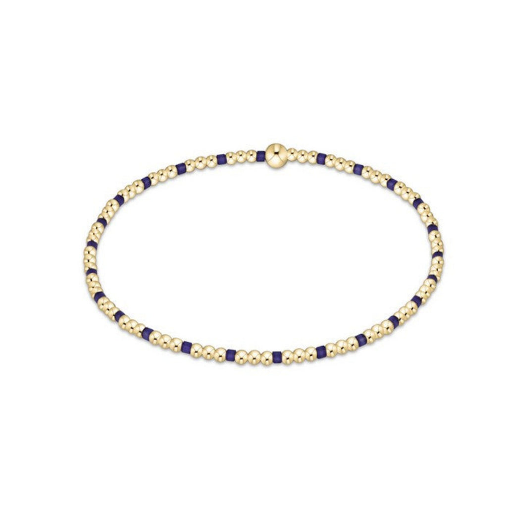 Gold and purple beaded necklace on a white background