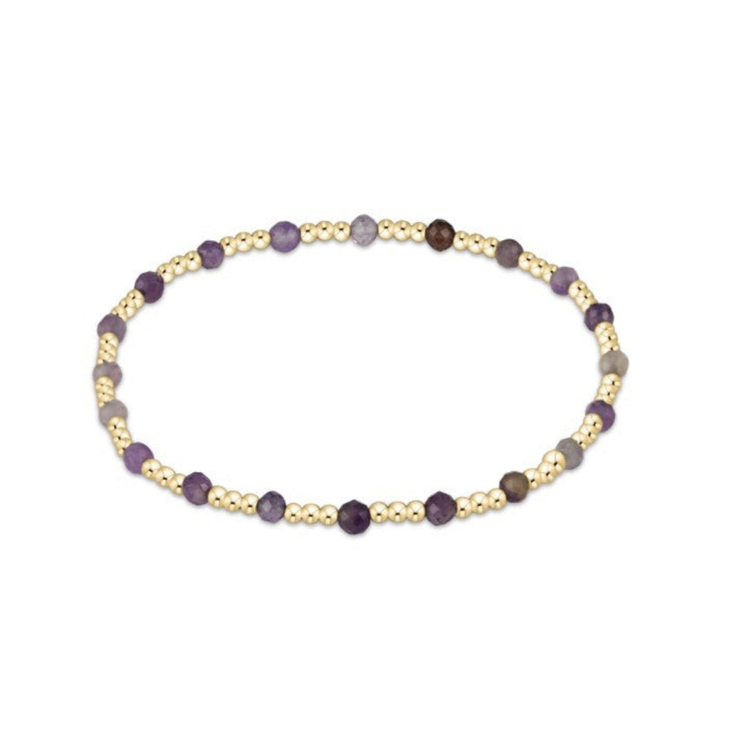 Bracelet with gold and amethyst stone on a white background