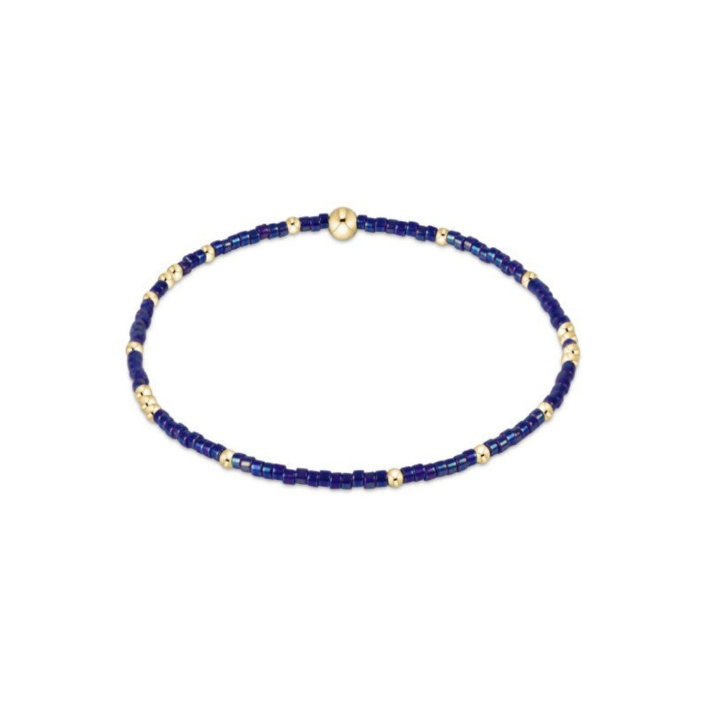 Blue beaded bracelet with gold accents on a white background