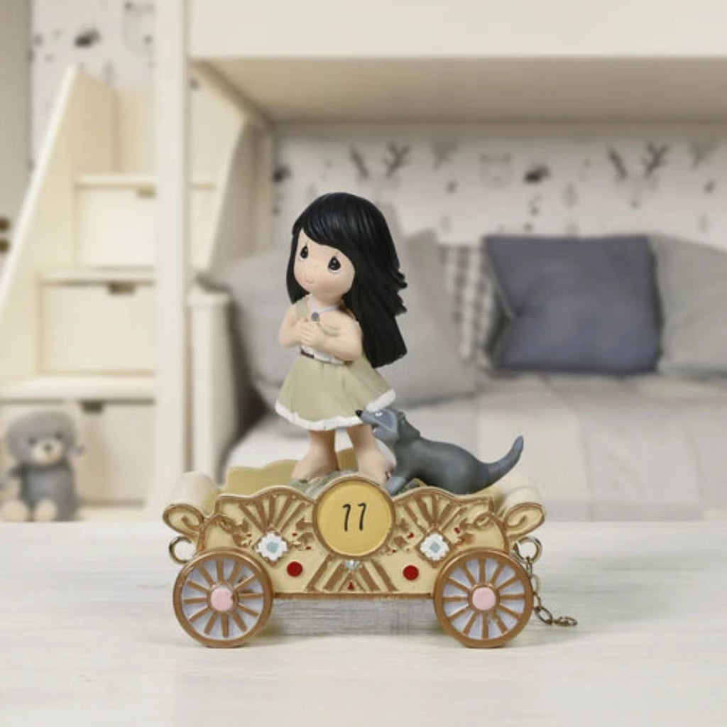 Decorative figurine of a girl with a dog on a cart in a bedroom setting