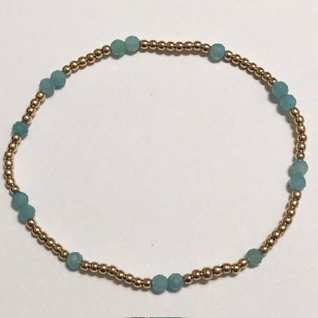 Gold bead bracelet with scattered acqua beads
