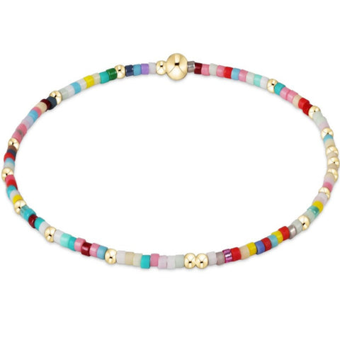 Multicolored beaded bracelet with gold accents on a white background