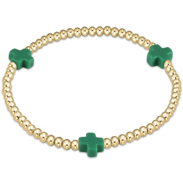 Gold beaded bracelet with 3 green crosses on a white background