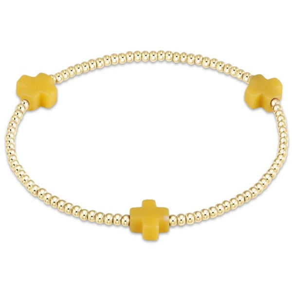 Bracelet with small gold beads and 3 small yellow crosses on a white background