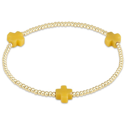 Bracelet with small gold beads and 3 small yellow crosses on a white background