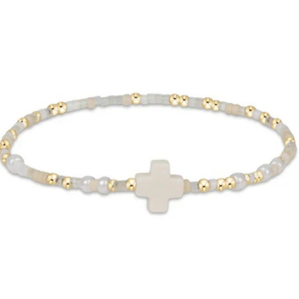 Bracelet with white beads and a gold cross on a white background