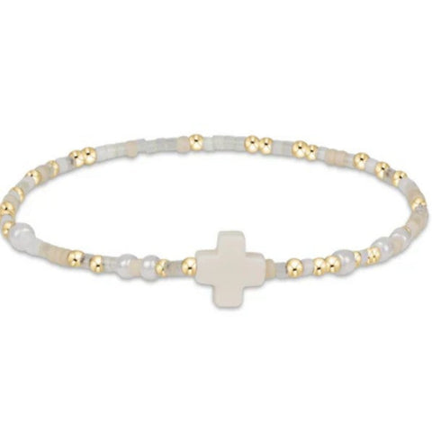 Bracelet with white beads and a gold cross on a white background