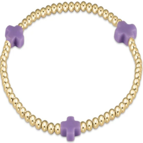 Gold beaded bracelet with 3 purple crosses on a white background