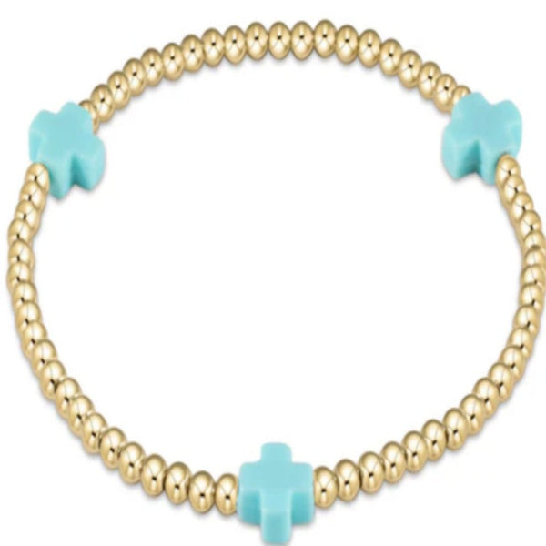 Gold beaded bracelet with 3 turquoise cross charms on a white background