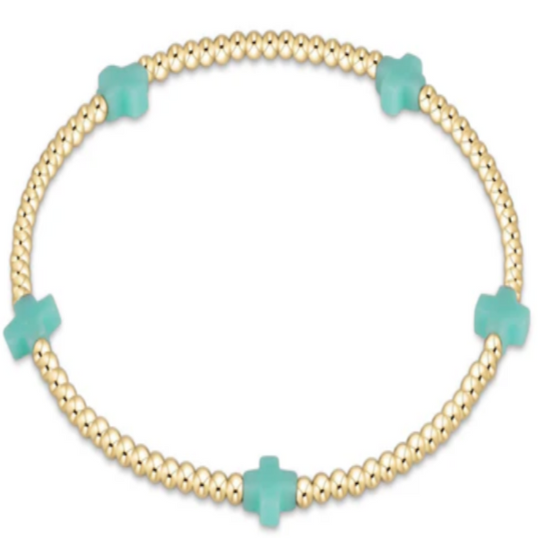 Gold bracelet with mint cross charms on a white background
