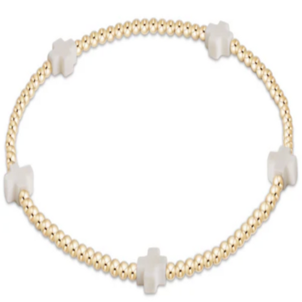 Bracelet with gold beads and off white cross charms on a white background