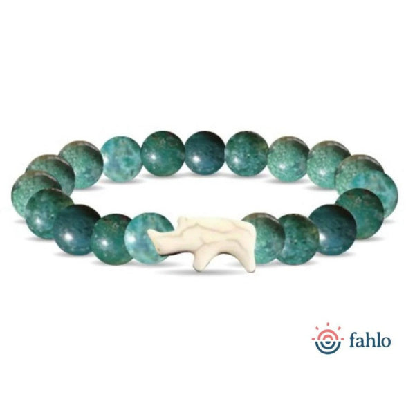 Green beaded bracelet with a ivory rhino charm on a white background.