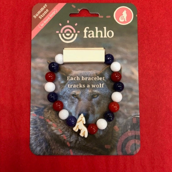 A beaded bracelet on a retail display card. The bracelet features red, white, and navy blue beads with a small white deer charm.