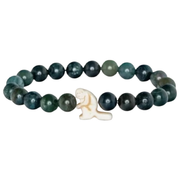 A beaded stretch bracelet featuring dark green and black marbled beads with a small cream-colored carved animal charm in the center, shown on a plain white background.
