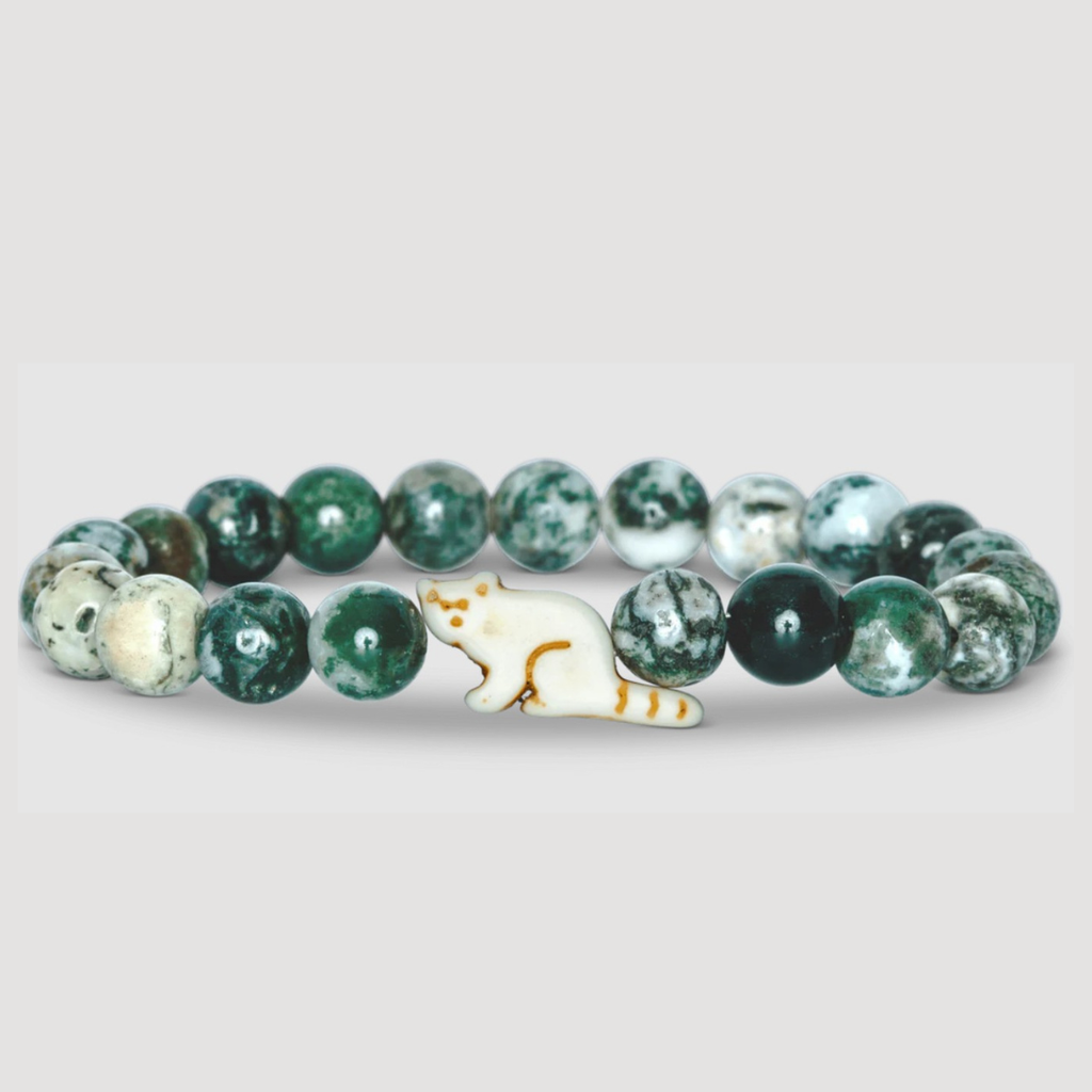 Green beaded bracelet with a red panda shaped charm on a light gray background