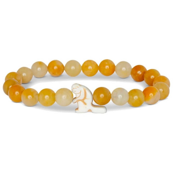 A beaded stretch bracelet featuring round agate-like beads in shades of orange, yellow, and cream, with a small white carved animal charm in the center, shown on a plain white background.