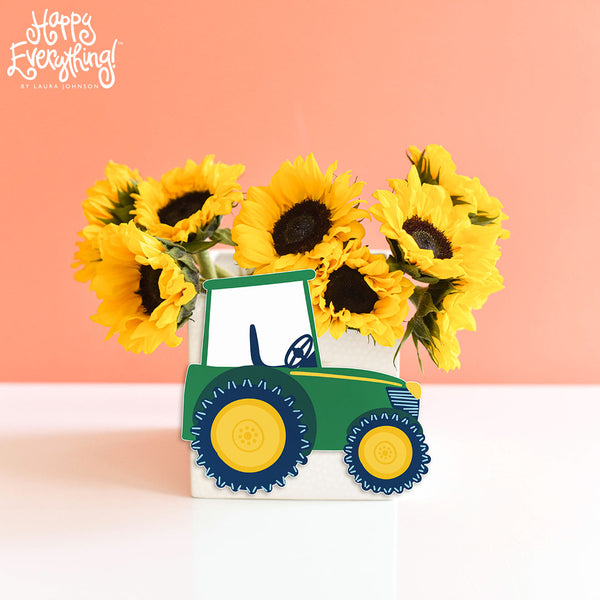 Green Tractor attached to white nesting cube with sunflowers inside