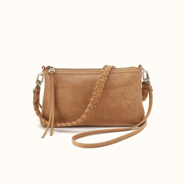 A tan faux-leather crossbody bag with a braided strap and silver-tone hardware, shown on a plain white background.