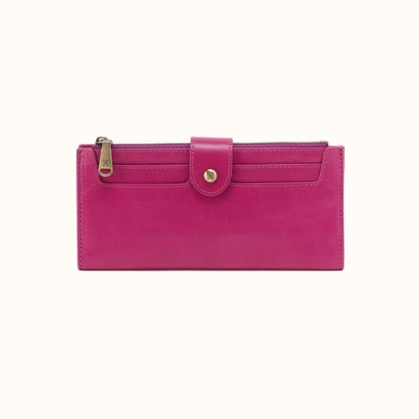 A bright pink leather zip-around wallet with a front flap pocket and gold-tone hardware, shown on a plain light background.