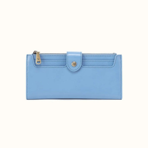 A light blue leather zip-around wallet with a front flap and gold-tone hardware, shown against a plain off-white background.