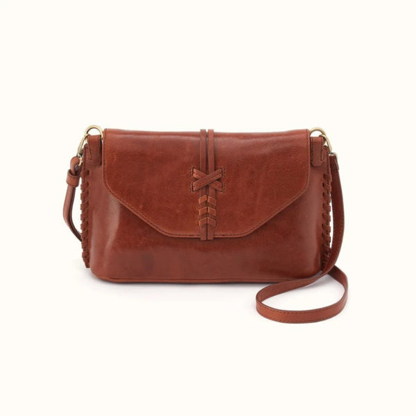 A brown leather crossbody bag with a front flap, braided strap details, and gold-tone hardware, shown on a plain light background.