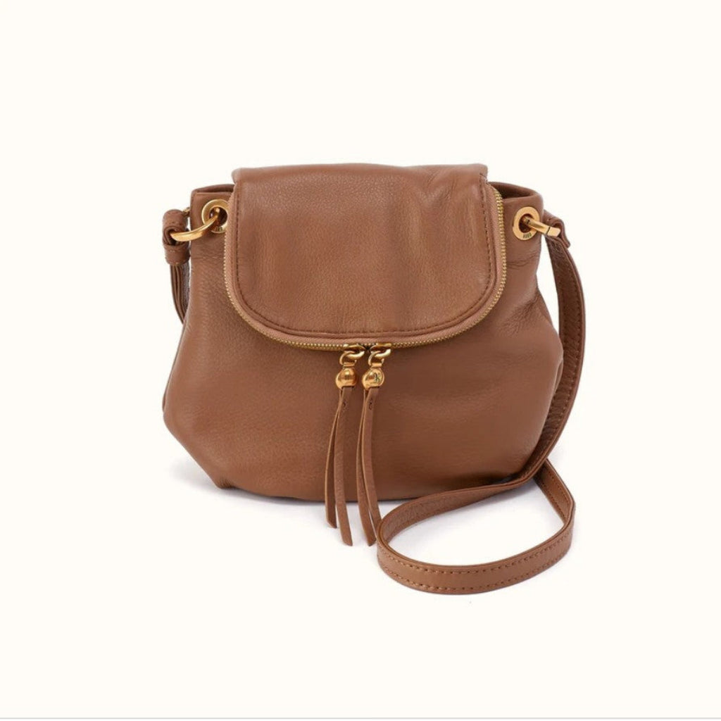 A brown leather crossbody bag with a front flap, gold-tone hardware, and a matching shoulder strap, shown on a plain white background.