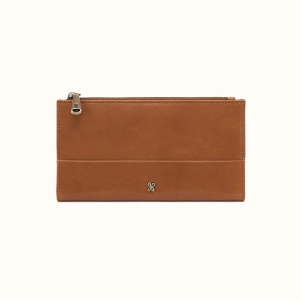 A tan leather zip pouch with a silver-tone metal zipper pull and a small silver logo on the front, shown against a plain white background.