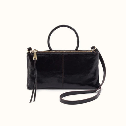 A black leather handbag with a top handle, a long shoulder strap, and a zippered top closure, shown against a plain off-white background.