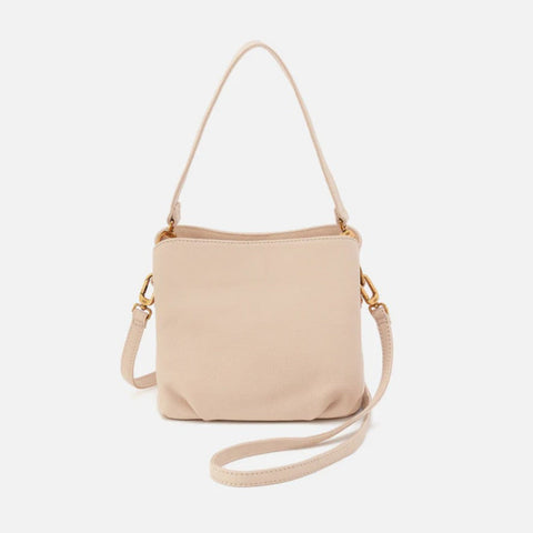 A light beige leather crossbody handbag with a matching shoulder strap and gold-tone hardware, shown against a plain light gray background.