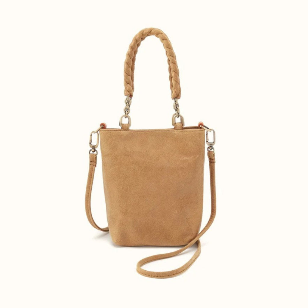 A tan suede bucket bag with a braided top handle, a detachable shoulder strap, and silver-tone hardware, shown against a plain off-white background.
