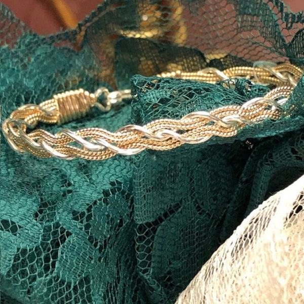 Gold and Silver Bracelet on Green Lace Background