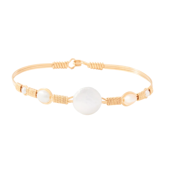 A delicate gold-plated bangle bracelet featuring a large white mother-of-pearl disc in the center, flanked by smaller white pearl beads and wrapped with gold-toned cord, shown on a plain white background.