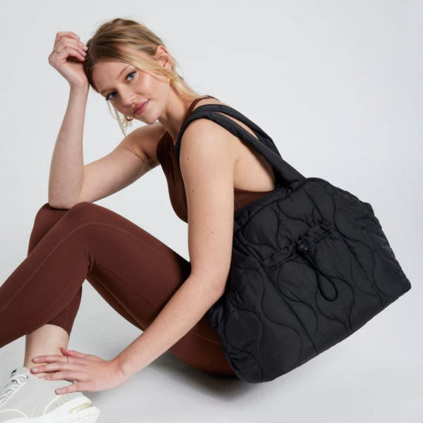 Woman Carrying a Black Puffy Tote Bag