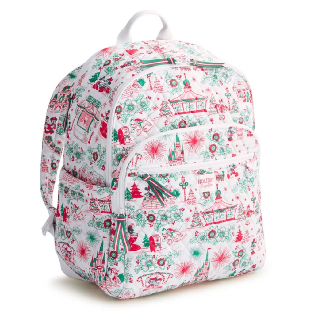 A white backpack featuring a festive Christmas-themed print with red and green illustrations of trees, snowflakes, gingerbread houses, and carousel scenes, shown against a plain white background.