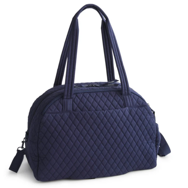 Back Side View of a navy blue quilted travel bag with dual top handles and a detachable shoulder strap, shown on a plain white background.