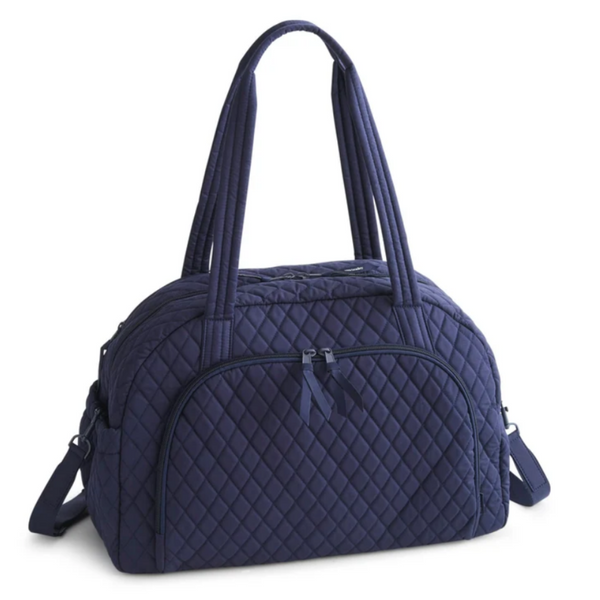 A navy blue quilted duffel bag with dual top handles and a detachable shoulder strap, shown on a plain white background.