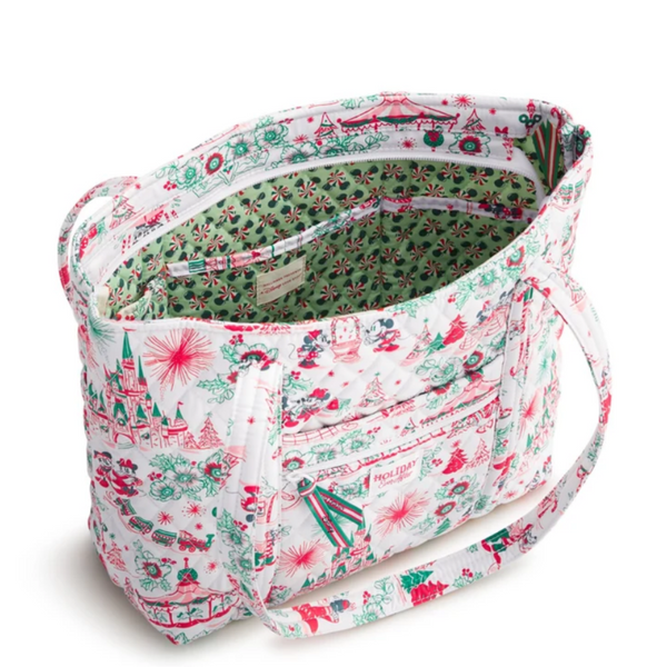 A fabric tote bag with a white background and a festive Christmas print featuring red and green illustrations of snowmen, sleighs, and snowflakes. The bag is shown open, revealing a green patterned lining, with a matching printed shoulder strap on a clean white background.