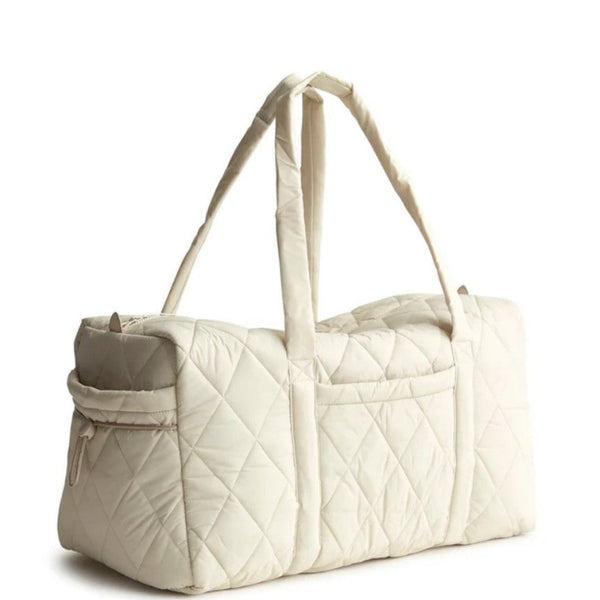 Beige quilted duffel bag on a white background