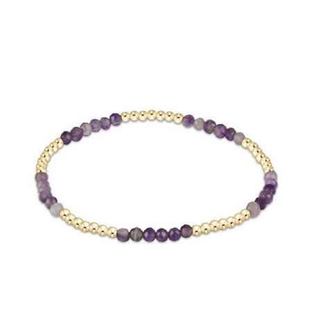 Bracelet with purple and gold beads on a white background