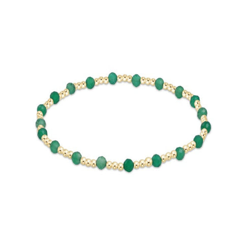 Bracelet with green beads and gold accents on a white background