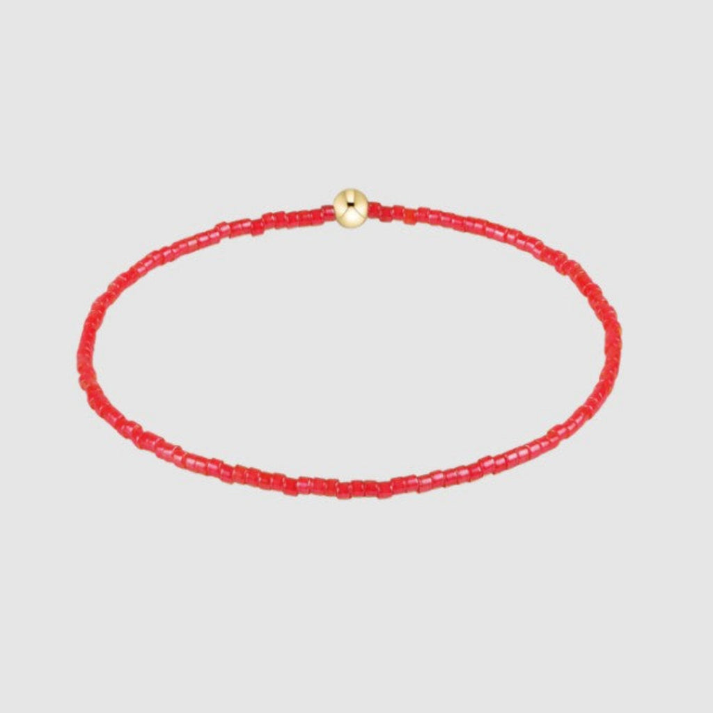 Orange beaded necklace with a gold clasp on a light gray background