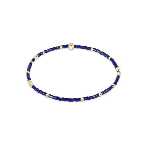 Blue beaded bracelet with gold accents on a white background