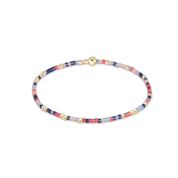 A delicate beaded bracelet with small multicolor beads in pink, blue, and red, accented by gold spacer beads and a gold clasp, shown on a plain white background.