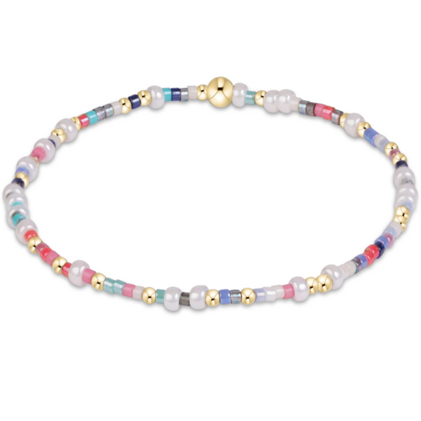 A beaded stretch bracelet featuring white faux pearls, small gold spacer beads, and multi-colored glass beads in pink, blue, and gray, arranged in a circle on a white background.