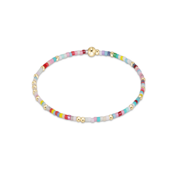 A delicate beaded bracelet with small pastel-colored cylindrical beads and alternating gold metallic spacer beads, featuring a gold clasp, shown on a plain white background.