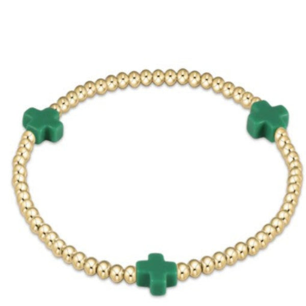 Gold beaded bracelet with 3 green crosses on a white background