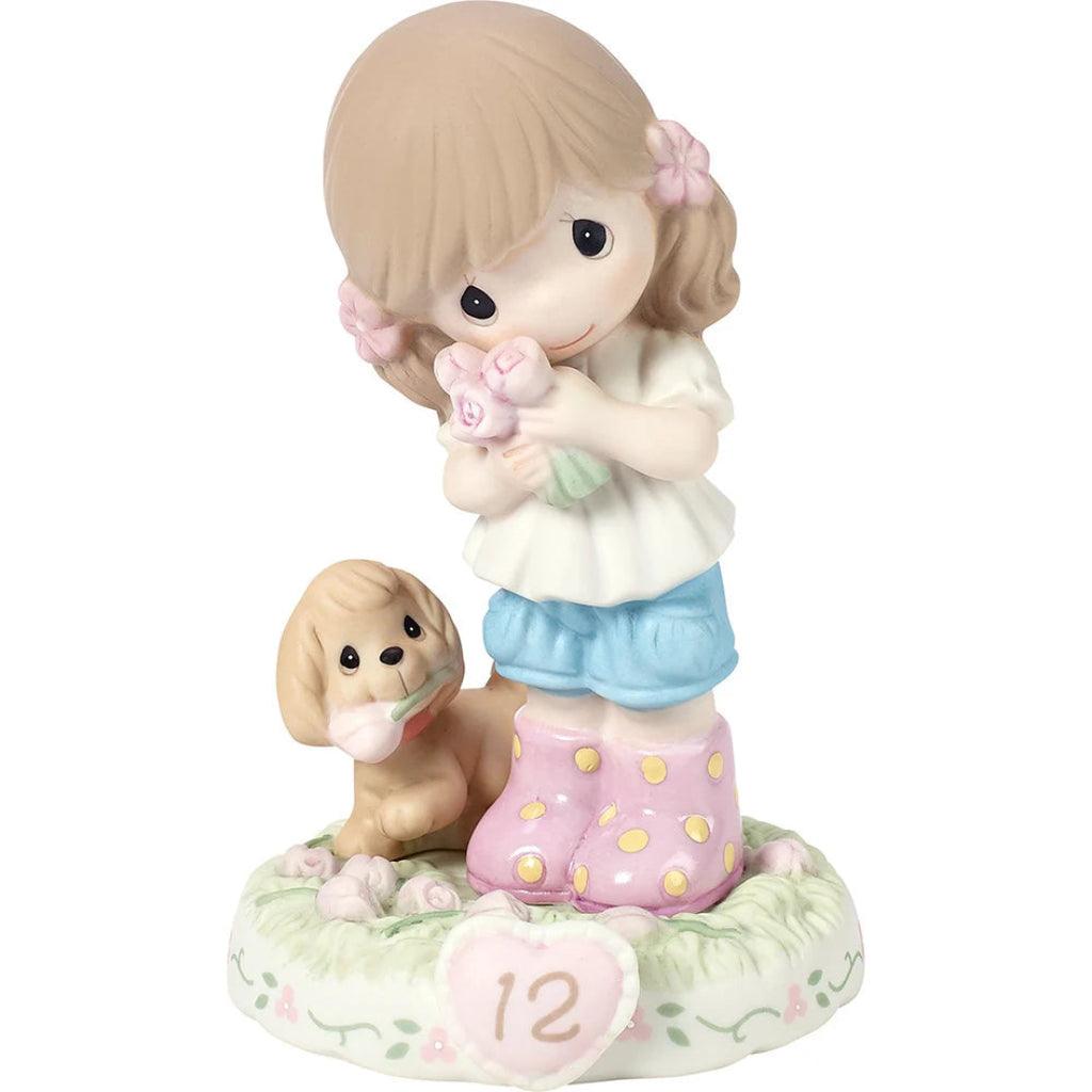 A ceramic figurine of a young girl with brunette hair holding pink roses, standing next to a small tan dog on a floral base with a heart-shaped plaque reading 12.