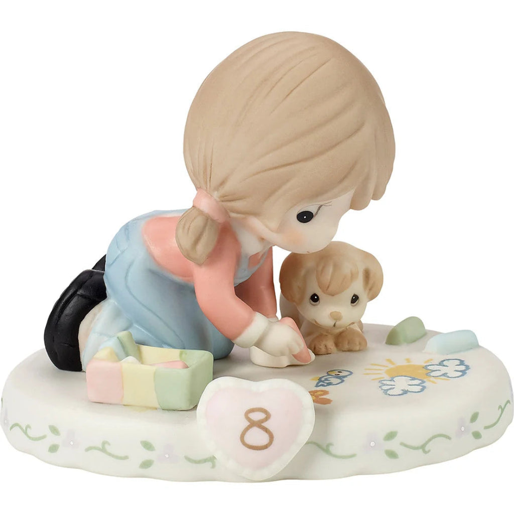 A ceramic figurine of a young girl with blonde hair kneeling beside a small puppy on a decorated base, shown on a plain white background.
